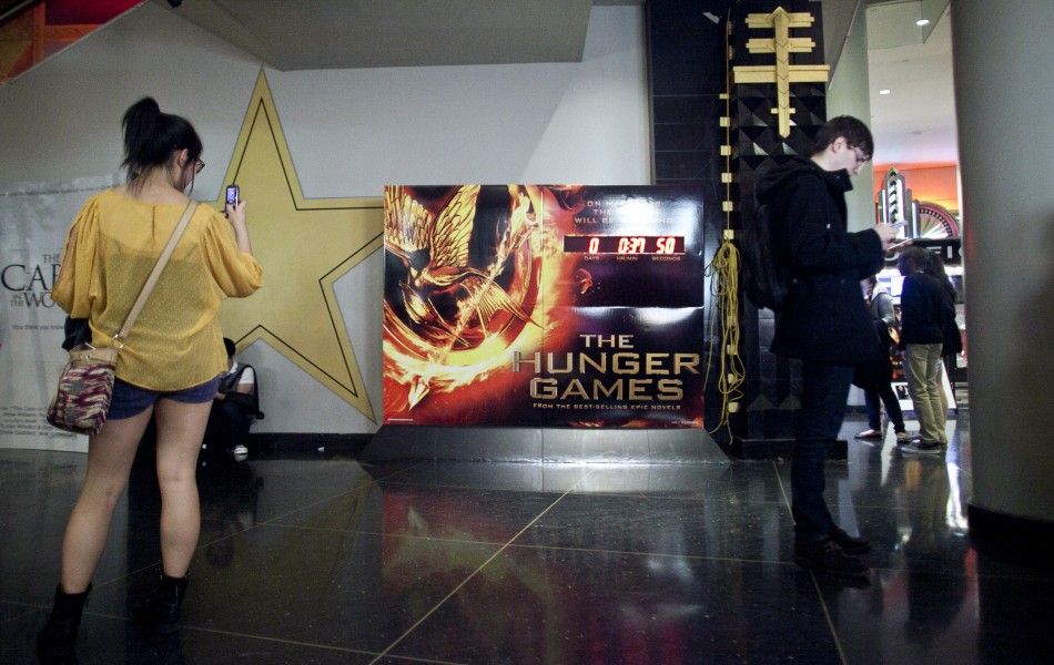 Movie-goers stand near a clock counting down the time till the midnight showing of quotThe Hunger Gamesquot at the AMC Loews Lincoln Square Theatre in New York March 22, 2012. The film is based on the popular young adult book series by Suzanne Collins