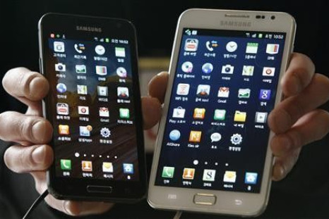 An employee poses with Samsung Electronics&#039; Galaxy phones at a store in Seoul March 14, 2012.