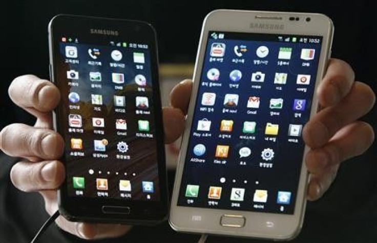 An employee poses with Samsung Electronics&#039; Galaxy phones at a store in Seoul March 14, 2012.