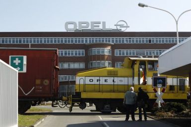 Workers wait in front of the Opel plant of Bochum