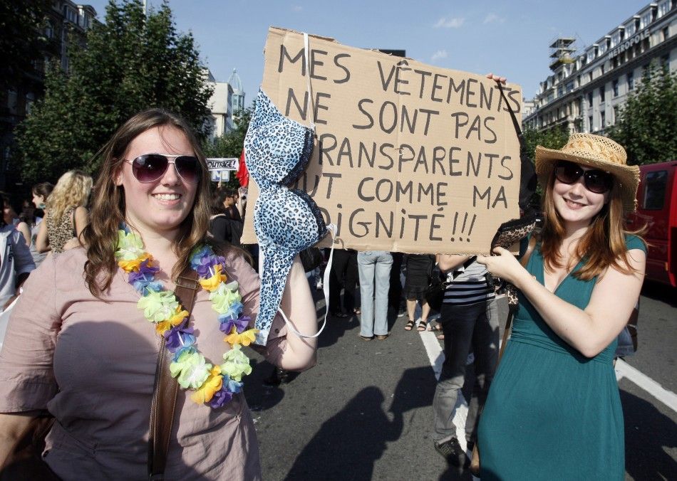 Women hold up a sign during a SlutWalk rally against sexual abuse and inequality in Brussels