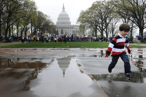 A boy jumps over a puddle during a Tea Party Patriots rally in Washington