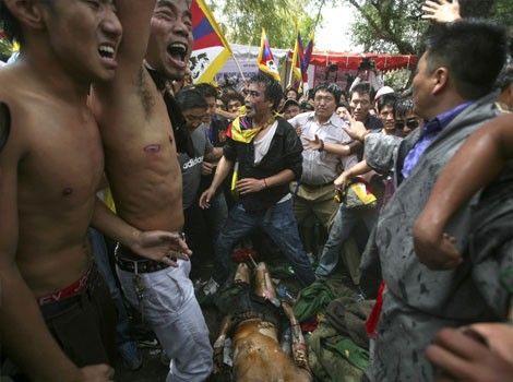 Tibetan activist and exile Jamphel Yeshi, 27, lies on the ground injured