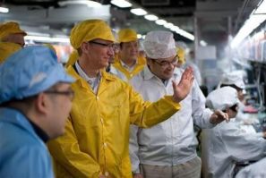Apple Chief Executive Officer Tim Cook (2nd L) talks to employees as he visits the iPhone production line at the newly built Foxconn Zhengzhou Technology Park, Henan province in this March 28, 2012 handout photo.