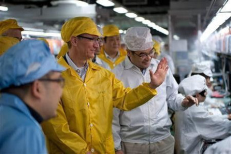 Apple Chief Executive Officer Tim Cook (2nd L) talks to employees as he visits the iPhone production line at the newly built Foxconn Zhengzhou Technology Park, Henan province in this March 28, 2012 handout photo.