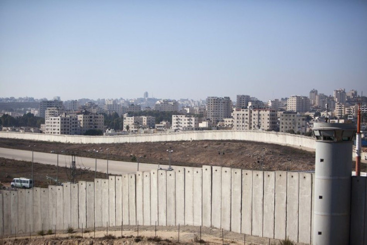 A taxi drives on a road near a section of the controversial Israeli barrier near the West Bank town of Kalandia near Jerusalem