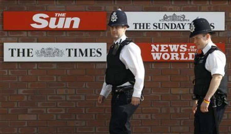 Police officers walk outside an entrance to News International in London in this July 10, 2011 file photo.