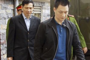 Pham Thanh Binh, former chairman of shipbuilding group Vinashin, and Nguyen Tuan Duong are escorted by policemen to a court in Hai Phong