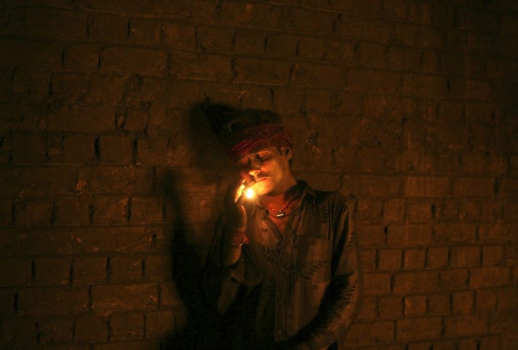 A labourer smokes as he takes a break inside a steel factory on the outskirts of Jammu March 15, 2012.