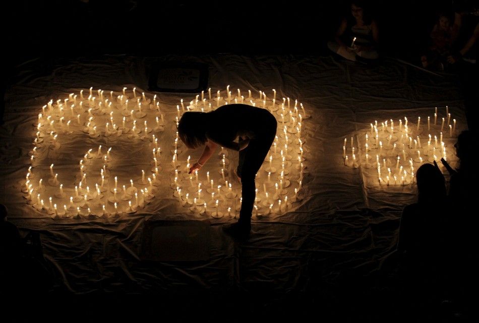 People light candles during Earth Hour after lights were turned off in Cali March 31, 2012. Lights started going off around the world on Saturday in a show of support for renewable energy. 