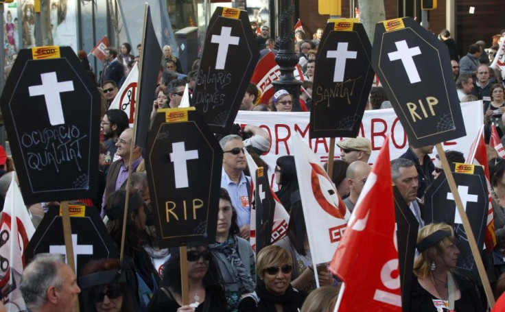 Protesters carry cardboard coffins that signify the death of decent employment, wages and public health in central Barcelona during a general strike in Spain