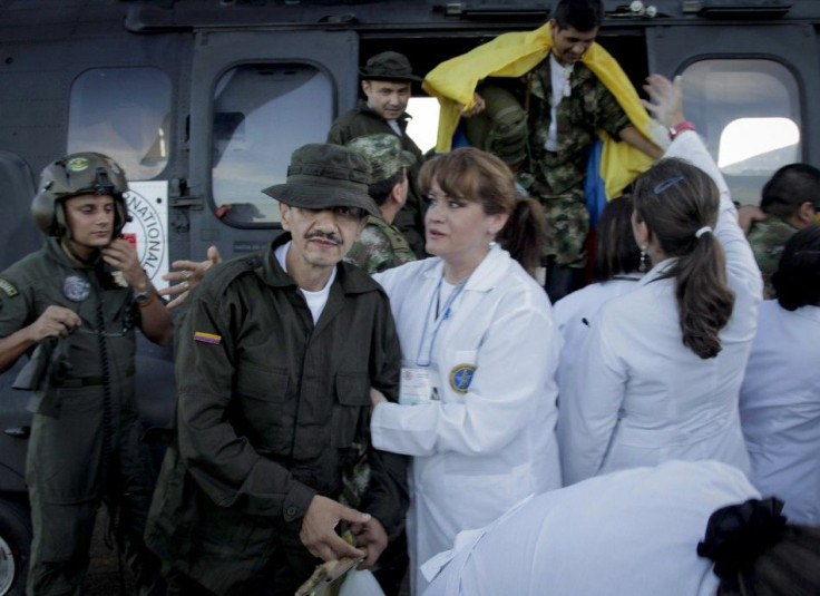 A Colombian policeman recently freed by FARC rebels is helped by a medical personnel after arriving at Villavicencio airport
