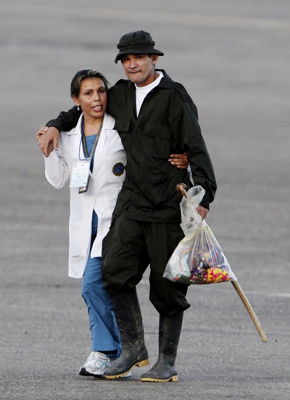 A recently freed hostage walks with a medical personnel as they arrive at Villavicencio039s airport