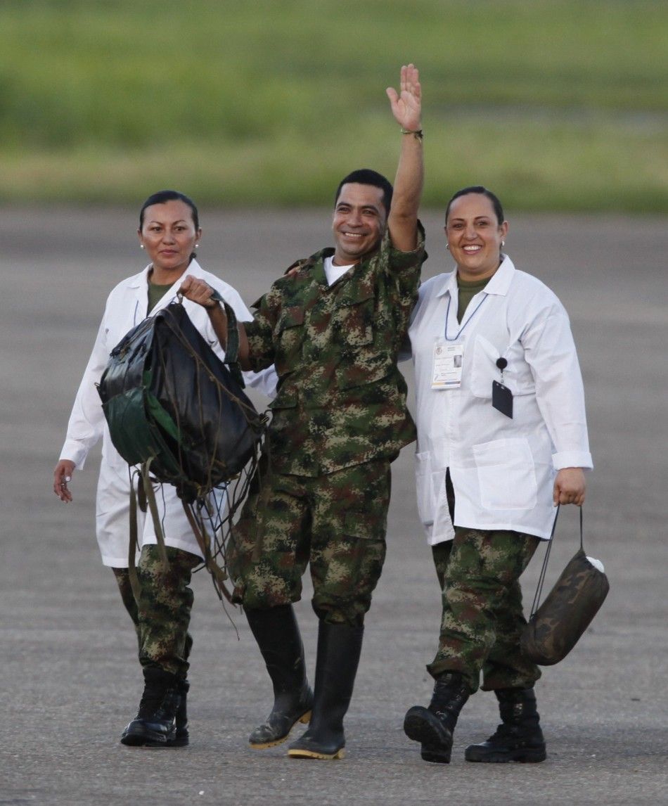 A soldier held hostage by FARC rebels waves next to medical personnel as he arrives at Villavicencio039s airport after being