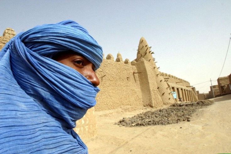 A Tuareg nomad stands near the 13th century mosque at Timbuktu, Mali.