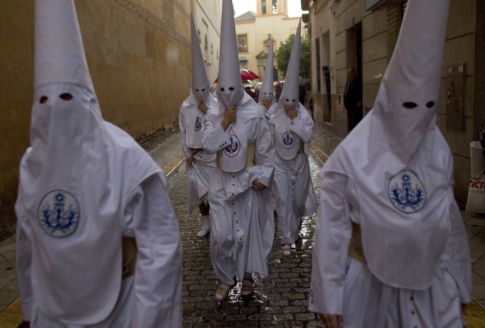 Penitents of quotLa Candelariaquot brotherhood walk to their churchduring Holy Week in Seville