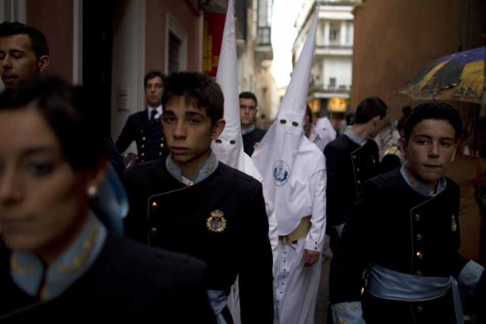 Penitents of quotLa Candelariaquot brotherhood walk to their churchduring Holy Week in Seville