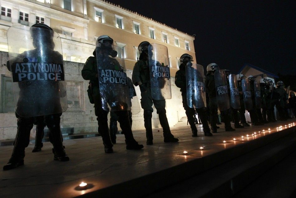 Candles commemorating the death of a pensioner are placed in front of the parliament in Athens