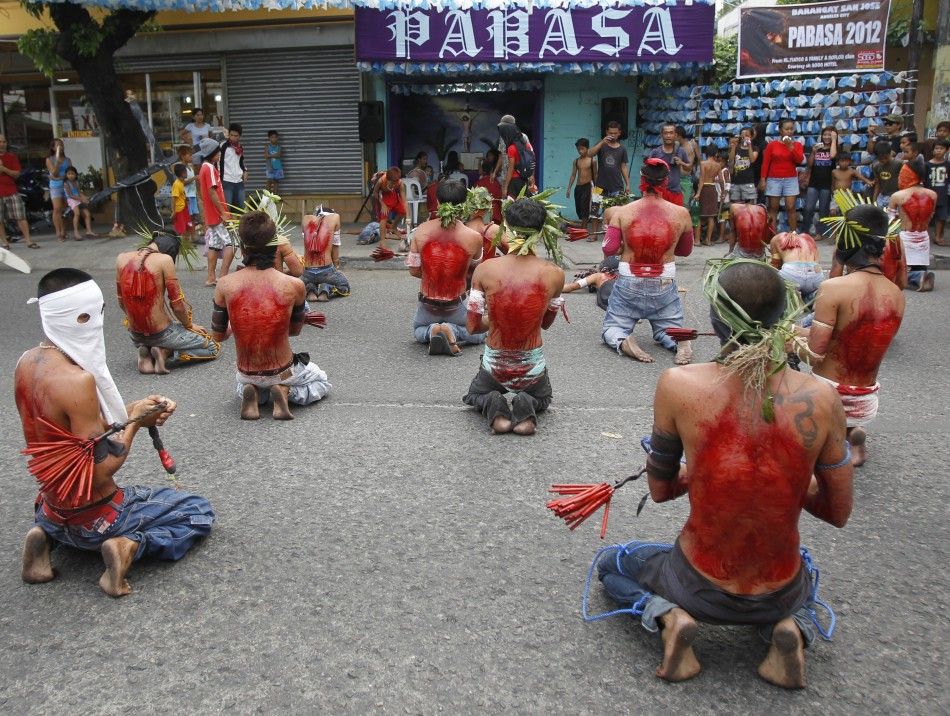  Hooded barefoot penitents performing self-flagellation to atone for their sins pray in front of a chapel in San Fernando, Pampanga in northern Philippines
