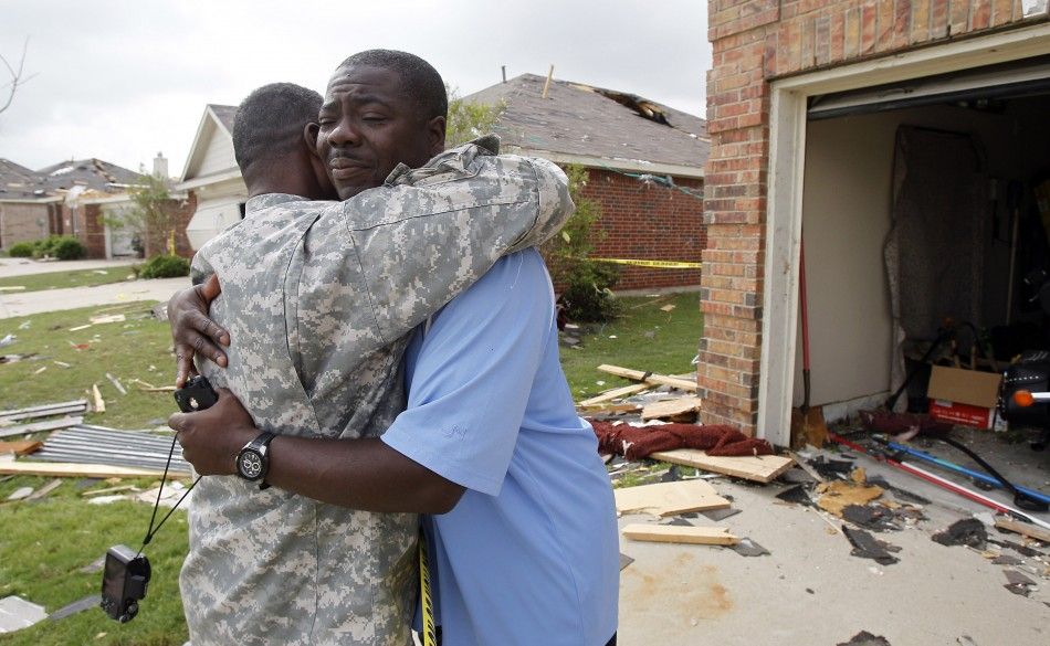 Homeowner Charles Paige hugs co-worker Morris Shepard during the cleanup effort in Forney