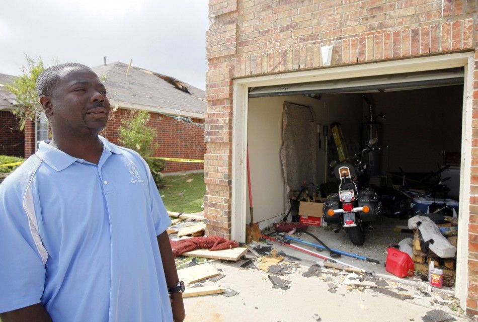 Homeowner Charles Paige looks at his home during the cleanup effort in Forney