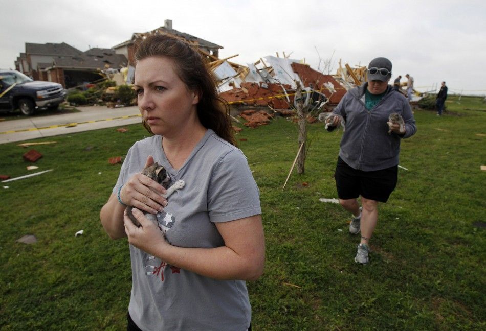 Brandy Beasley and Bobbie Deen carry kittens they rescued from a home demolished by the tornado during the cleanup effort in Forney