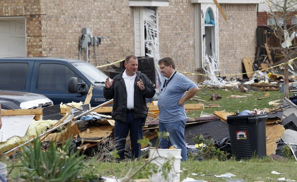  A fire department official talks to a resident during the cleanup effort in Forney