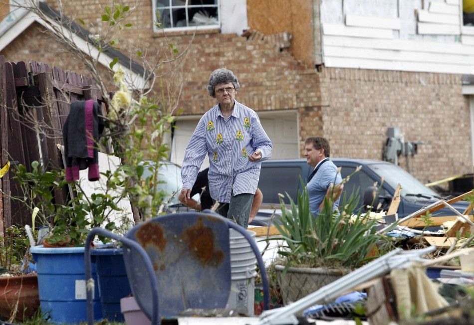 An unidentified woman walks through the remains of a home during the cleanup effort in Forney