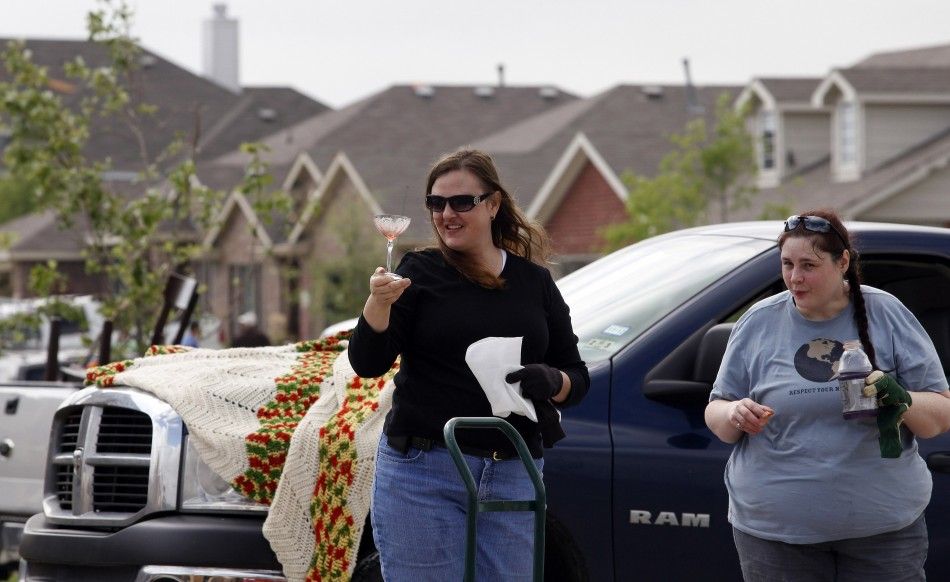 Theresa Winters smiles at the sight of a glass which survived the storm during the cleanup effort in Forney