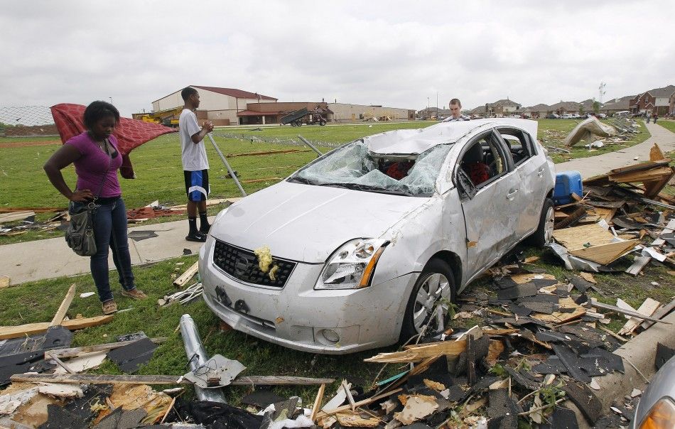 A girl looks at the remains of her car during the cleanup effort in Forney