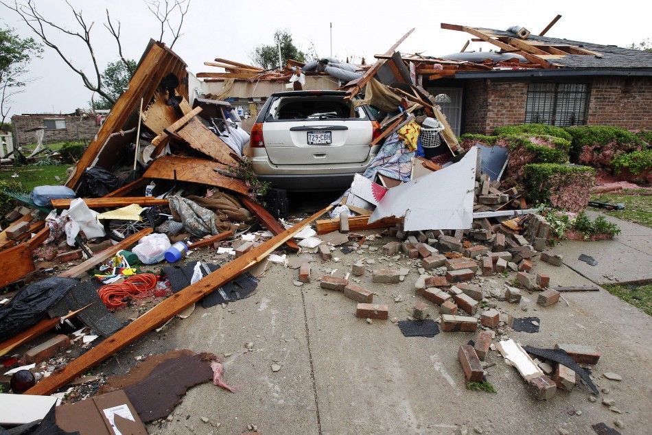 A vehicle rests in the driveway of a home destroyed by a series of tornadoes ripping through the Dallas suburb of Lancaster
