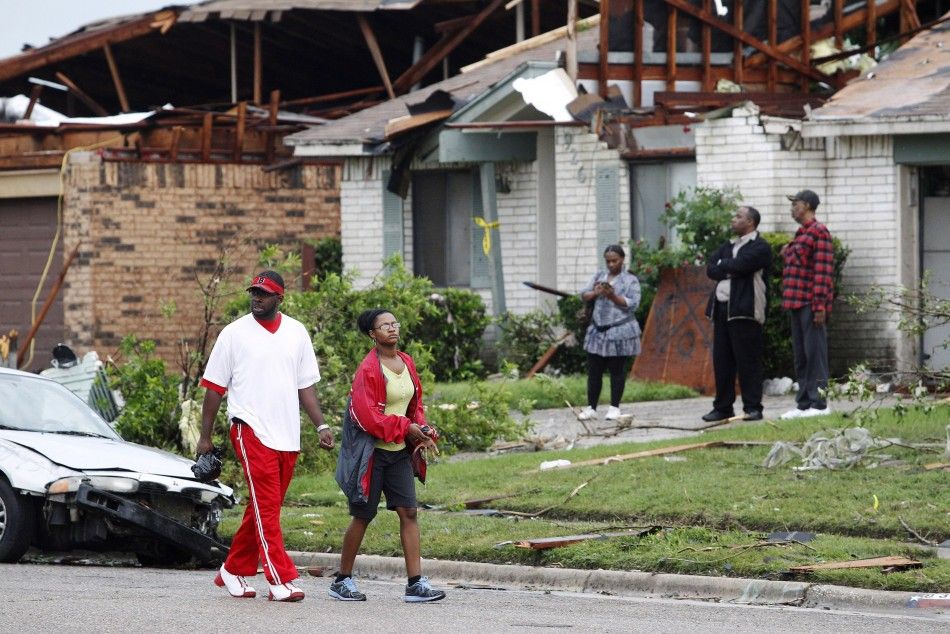 Residents survey the damage to their neighborhood after a series of tornadoes ripped through the Dallas suburb of Lancaster