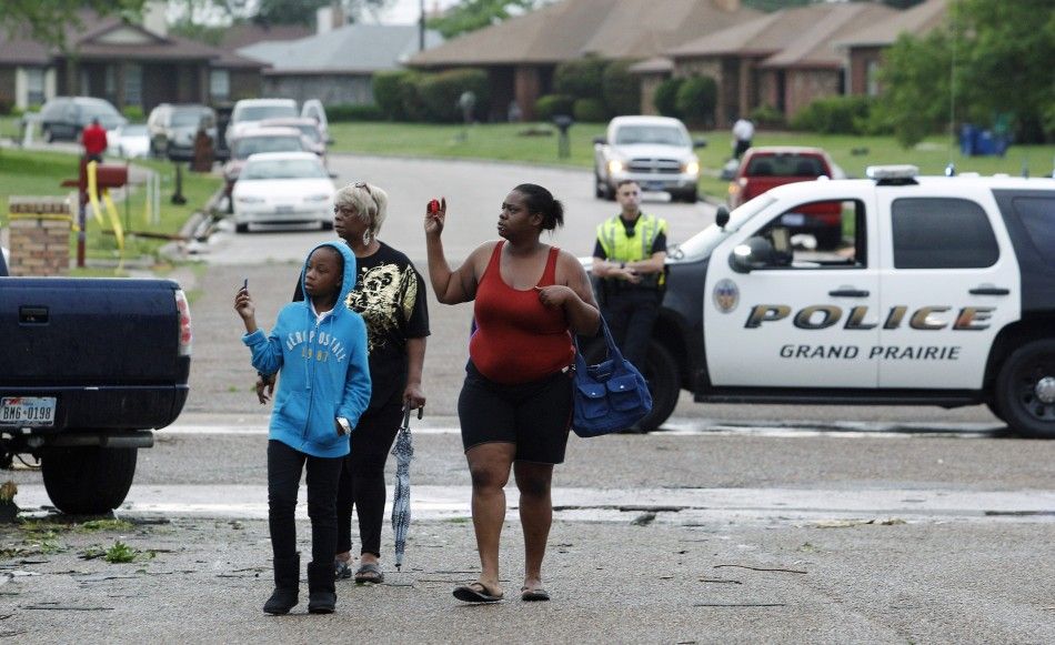 Residents survey the damage to their neighborhood after a series of tornadoes ripped through the Dallas suburb of Lancaster