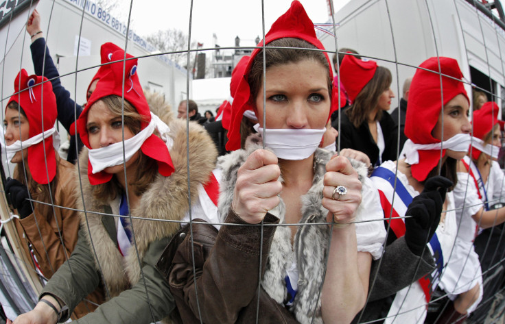 Girls dressed in costumes from the French revolution look through a fence as they take part in a protest march over France's planned legalisation of same-sex marriage in Paris 