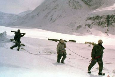 Pakistani soldiers, tied to each other for safety in hostile weather conditions, carry their weapons some time in June 1999 as they cross a snowy field on the Siachen Glacier in Pakistan.