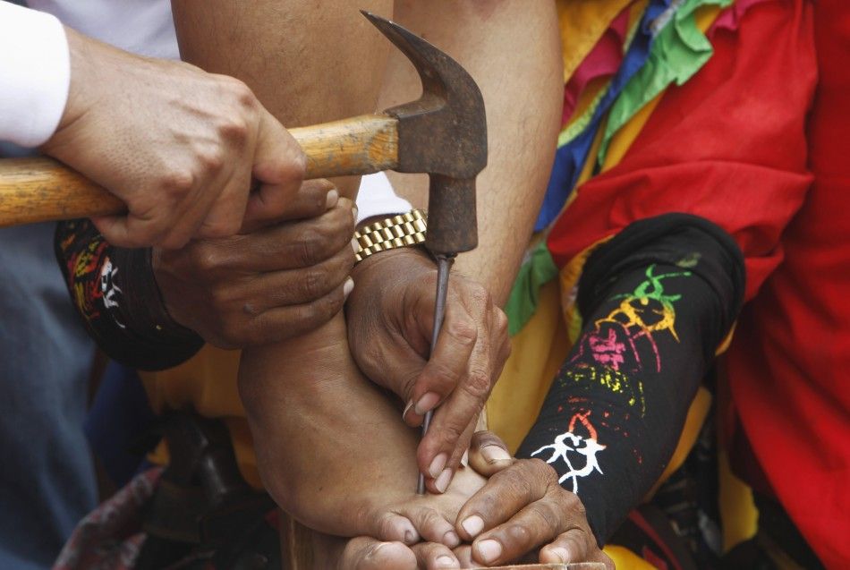 Precy Valencia, a penitent, has her feet nailed to a wooden cross as part of a voluntary ritual to mark the death of Jesus Christ on Good Friday in the town of Paombong in the Bulacan province, north of Manila, April 6, 2012. Numerous penitents were naile