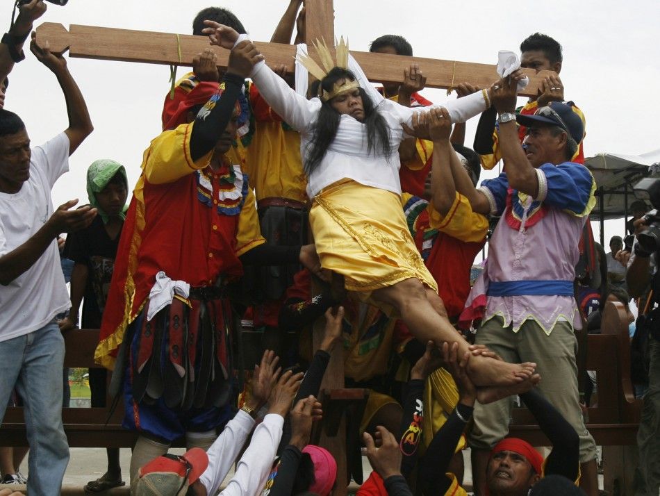 Precy Valencia, a penitent, is lowered from the wooden cross after she was nailed to it as part of a voluntary ritual to mark the death of Jesus Christ on Good Friday in the town of Paombong in Bulacan province, north of Manila, April 6, 2012. Numerous pe