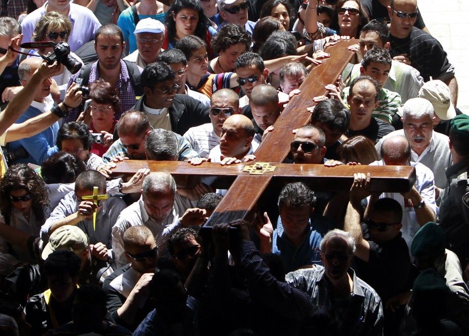 Arab Christian worshippers hold a cross as they enter the Church of the Holy Sepulchre during a procession on Good Friday in Jerusalems Old City April 6, 2012. Christian worshippers retraced the route Jesus took along Via Dolorosa to his crucifixion in t