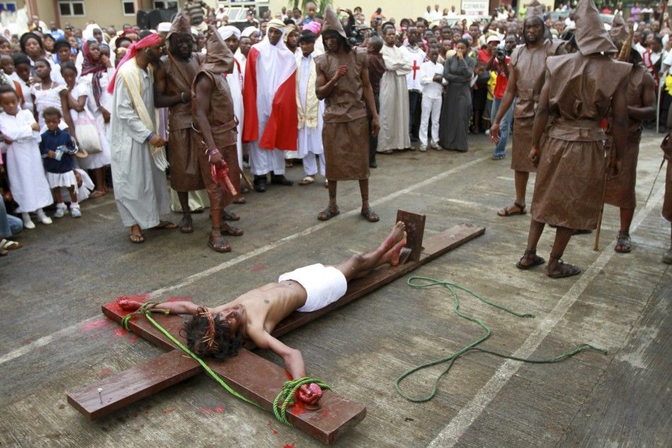 People watch as a man dressed as Jesus Christ is mounted on a cross in front of a Catholic church during a ritual to mark the death of Christ on Good Friday in Nigerias commercial capital Lagos April 6, 2012. 