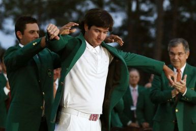 Bubba Watson gets his green jacket from 2011 Masters Tournament champion Charl Schwartzel as Augusta National Golf Club Chairman William Porter Payne, right, applauds the 2012 champ on Sunday in Augusta, Ga.