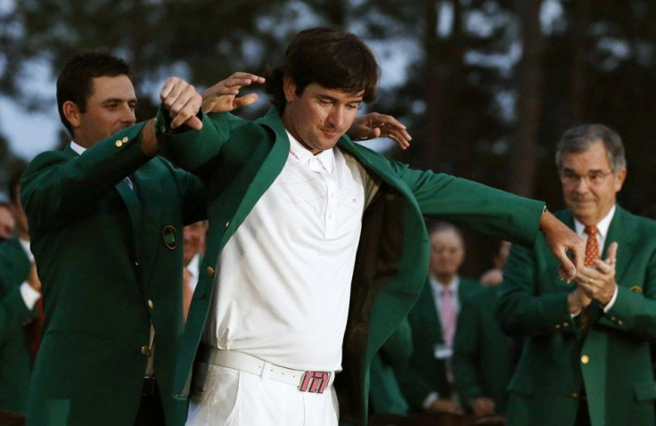 Bubba Watson gets his green jacket from 2011 Masters Tournament champion Charl Schwartzel as Augusta National Golf Club Chairman William Porter Payne, right, applauds the 2012 champ on Sunday in Augusta, Ga.