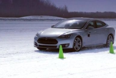 A Tesla Model S drives in the snow.