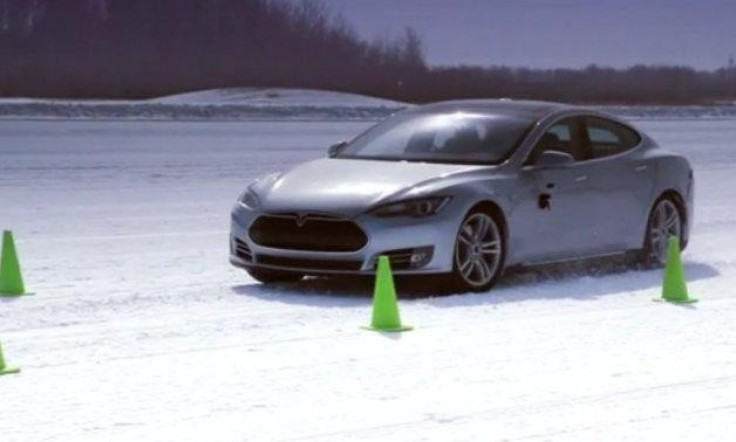 A Tesla Model S drives in the snow.