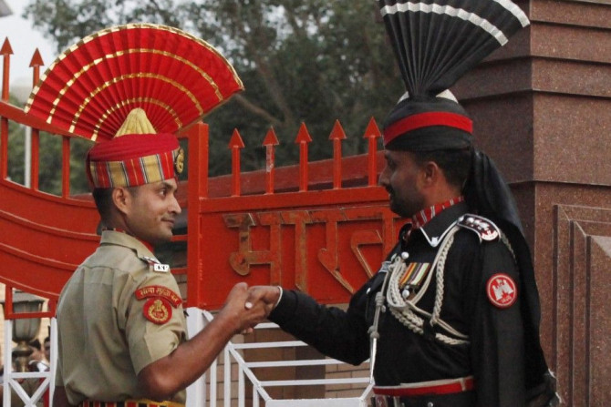 A Pakistani Ranger and an Indian Border Security Force officer shake hands during the daily parade at the Pakistan-India joint check-post at Wagah border