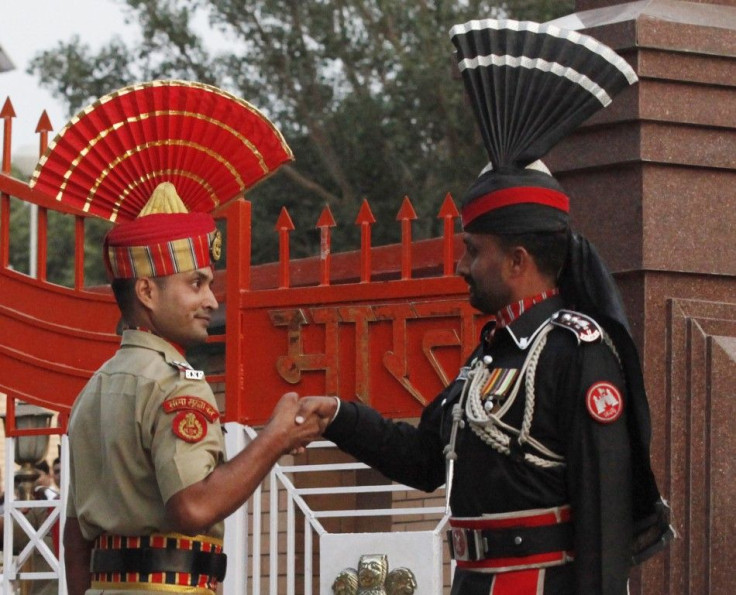 A Pakistani Ranger and an Indian Border Security Force officer shake hands during the daily parade at the Pakistan-India joint check-post at Wagah border