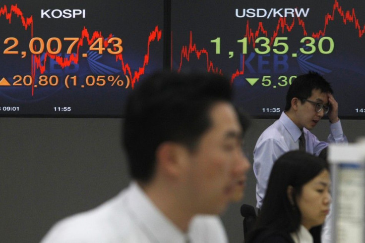 Currency dealers work in a dealing room of a bank in Seoul