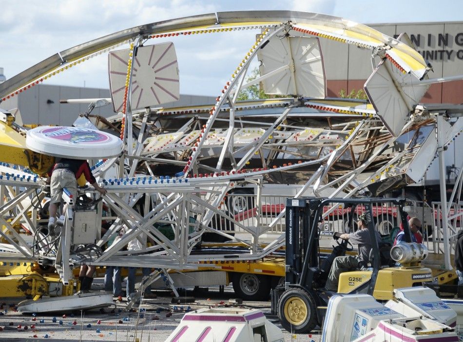 Workers try to dismantle and untangle a Ferris wheel that was flipped over by a tornado in southern Wichita
