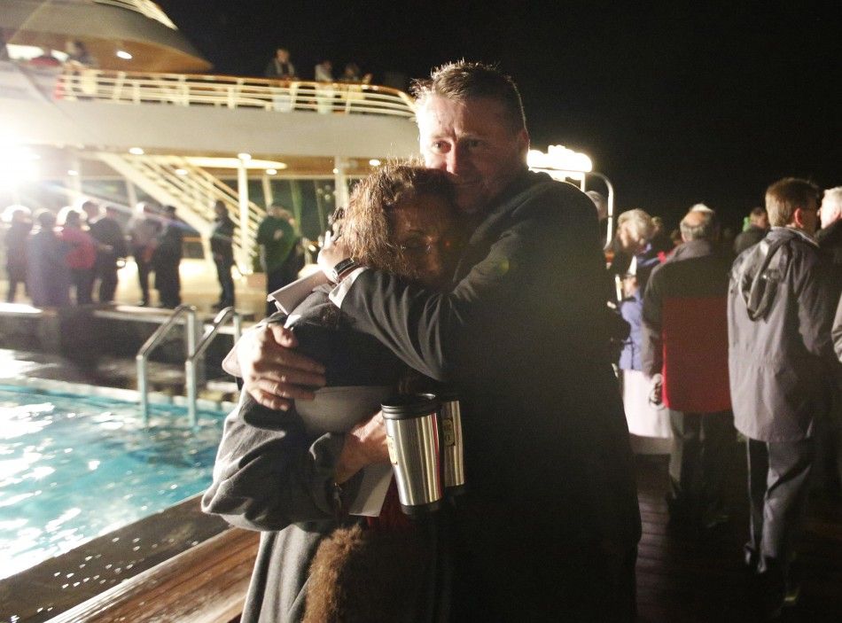 Passengers embrace after a service of remembrance aboard the Titanic Memorial Cruise in the western Atlantic Ocean