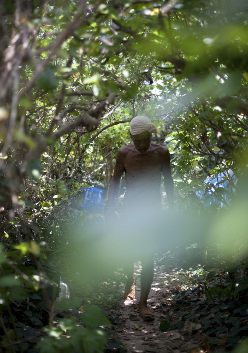 Seventy-six-year-old naked hermit Nagasaki walks through jungle on Sotobanari island, Okinawa prefecture, Japan