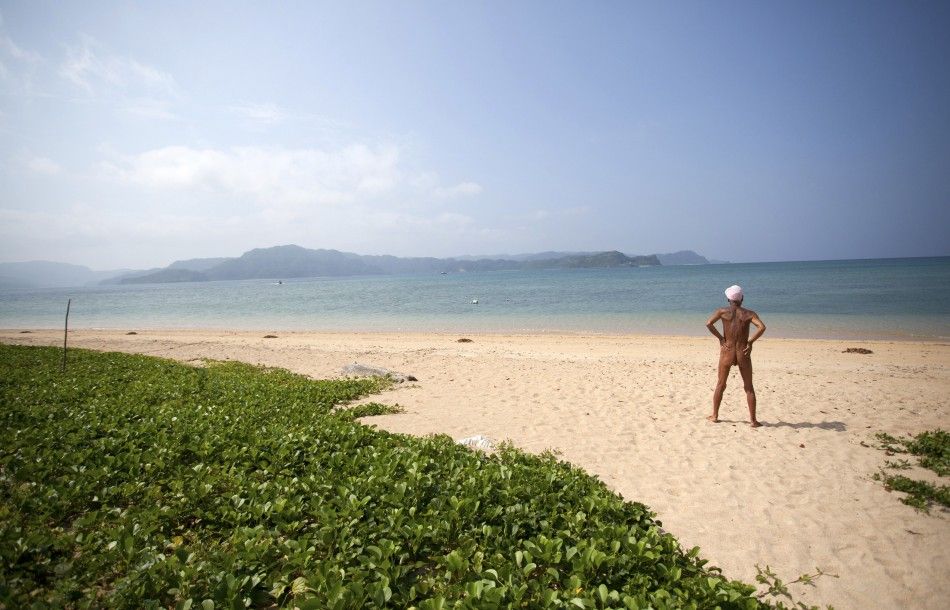 Seventy-six-year-old naked hermit Nagasaki looks at the sea from beach on Sotobanari island, Okinawa prefecture, Japan